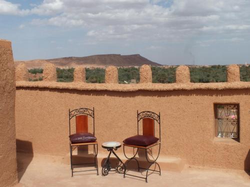 two chairs and a table on top of a building at Hotel Tomboctou in Tinerhir