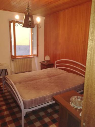 a bedroom with a bed in a room with a window at Comodo appartamento nel centro di Sassello in Sassello