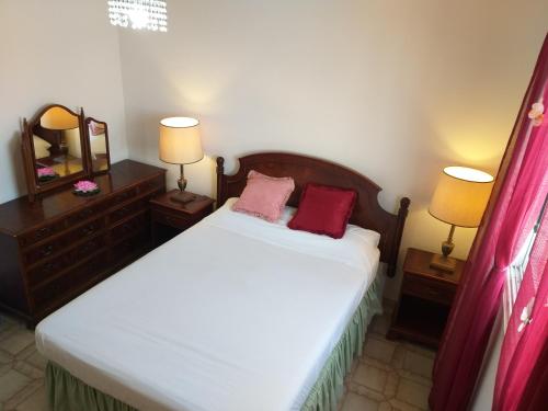 a bedroom with a bed with two night stands and two lamps at 777 Beach Guesthouse in Paphos City