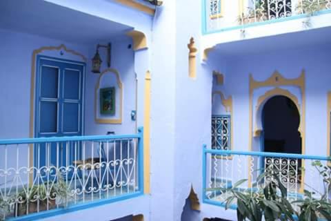 a building with a blue door and a balcony at Hôtel Dar Terrae in Chefchaouene