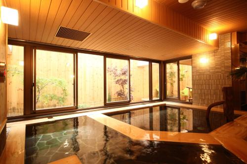 a house with a swimming pool in a room with windows at Dormy Inn Premium Sapporo in Sapporo