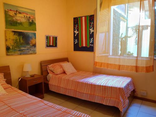 sypialnia z 2 łóżkami i oknem w obiekcie Apartment Inn w mieście Aci Castello