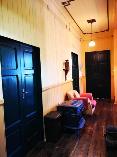 a room with a couch and a chair and two doors at Baita Marilù in Lorica
