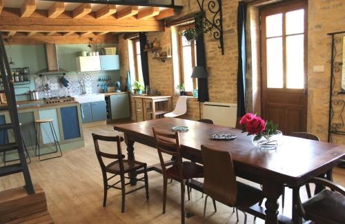 una cucina e una sala da pranzo con tavolo e sedie in legno di Anna's Guest House a Longvay
