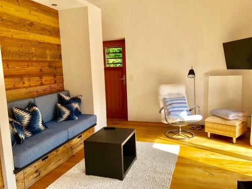 a living room with a blue couch and a chair at Ferienwohnung Springer in Schliersee