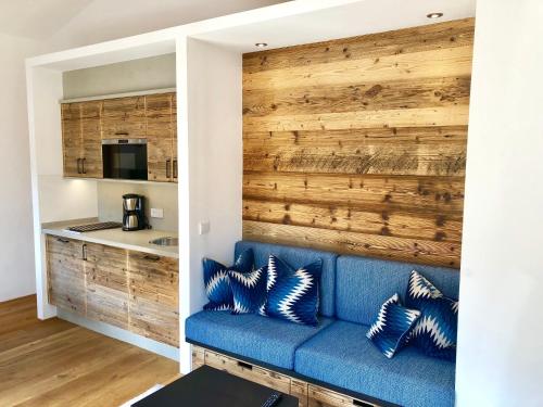 a living room with a blue couch and a wooden wall at Ferienwohnung Springer in Schliersee