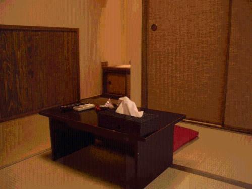 a black desk in a room with a door at Family Ryokan Kawakyu with Showa Retro, private hot spring in Ibusuki