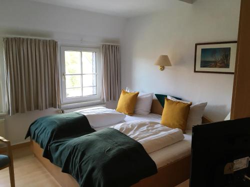 a hotel room with two beds and a window at Hotel-Pension Seeadler in Prerow