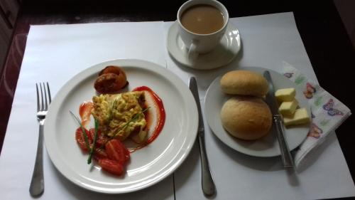 Lungi的住宿－Airport Lodge Lungi，餐桌,带两盘食物和一杯咖啡的桌子