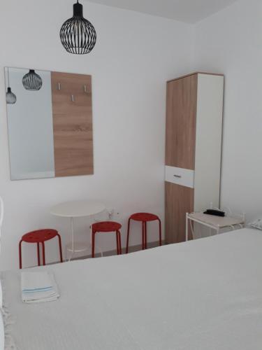 a kitchen with a white table and red stools at Motel Traffic in Linteşti
