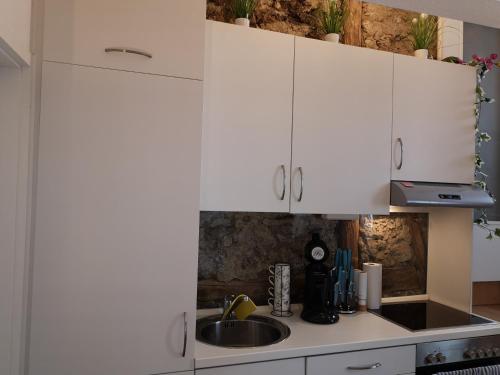 a kitchen with white cabinets and a sink at City Apartments in Göttingen