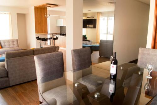 a living room with a table with a wine bottle on it at Residencial Cafferata in Lima