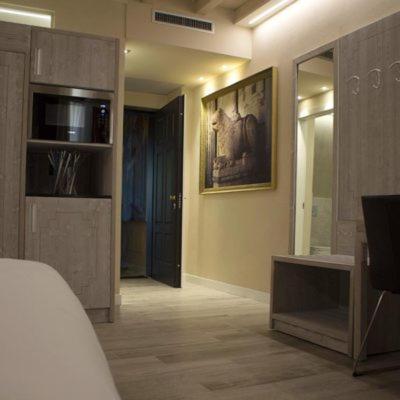 a room with a bed and a tv and a mirror at Palazzo Domanto Apartments Parma in Parma