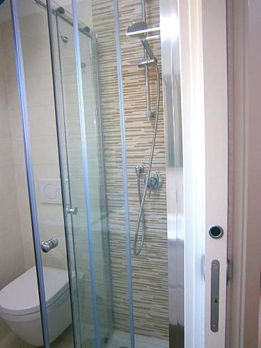 a bathroom with a glass shower with a toilet at Cà Bianca in Bibione