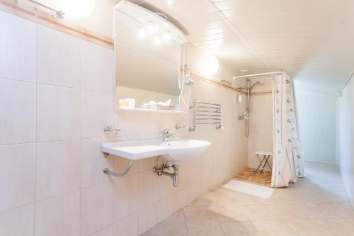 a white bathroom with a sink and a mirror at House Marija in Vilnius