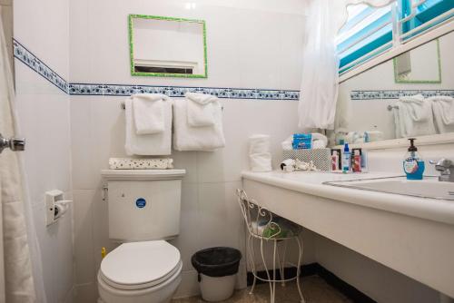 a bathroom with a white toilet and a sink at Beach Palms Villa in Silver Sands