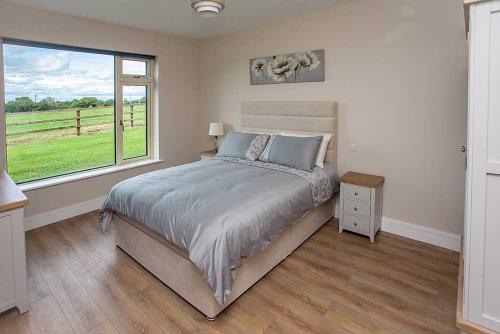 Un dormitorio con una cama grande y una ventana en Greenway Holiday Home, en Dungarvan