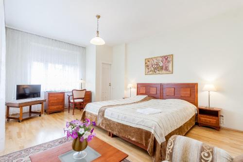 a bedroom with a bed and a desk and a tv at House Marija in Vilnius