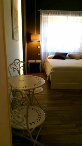a room with a table and a bed and a window at Il Mare Di Roma Luxury in Lido di Ostia