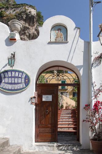 a building with a wooden door and a stairway at Hotel L'Argine Fiorito in Atrani