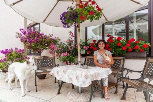 a woman sitting at a table with a dog at House Marija in Vilnius