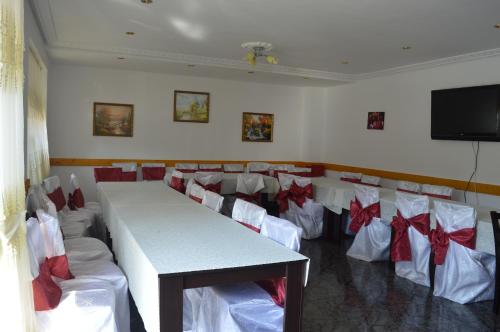 a conference room with a table and chairs with bows at Pensiunea Stan in Cisnădie