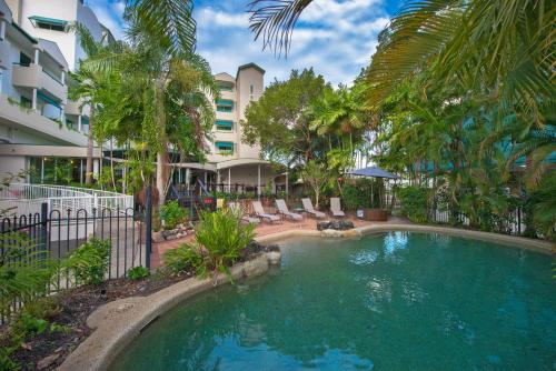 a swimming pool in front of a building at Cairns Sheridan Hotel in Cairns