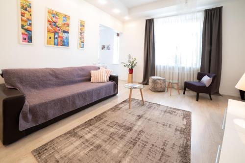 ein Wohnzimmer mit einem Sofa und einem Tisch in der Unterkunft Home In Riga in Riga