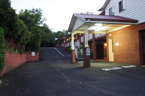 an empty street with a brick building and a sidewalk at Lismore Wilson Motel in Lismore