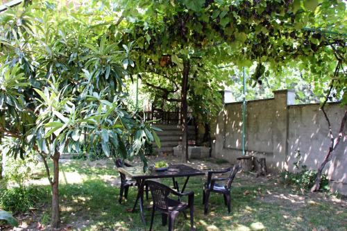 a table and chairs under a tree in a yard at Hotel Liva in Mtskheta
