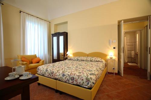 Habitación de hotel con cama y silla en Villa D'Azeglio, en Albiano dʼIvrea