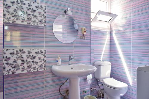 La salle de bains est pourvue d'un lavabo, de toilettes et d'un miroir. dans l'établissement Two-Bedroom Apartment at Mohamed Farid Street, au Caire