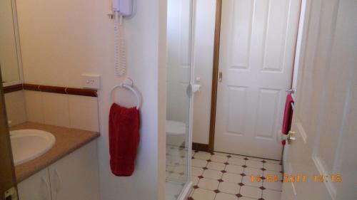 a bathroom with a white toilet and a red towel at Summers Rest Units in Port Campbell