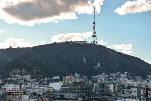 a hill with a windmill on top of a city at Eleon Boutique Hotel in Tbilisi City