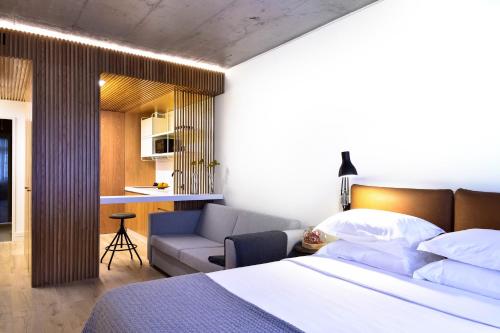 1 dormitorio con cama, sofá y cocina en My Story Apartments Porto - Santa Catarina, en Oporto