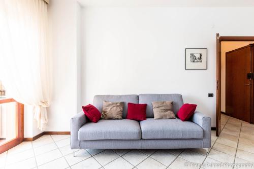a gray couch with red pillows in a living room at Giusy Monreale Apartment in Cagliari
