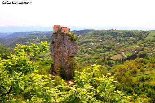 a house on top of a rock on a hill at Butichi Guest House in Chiatʼura