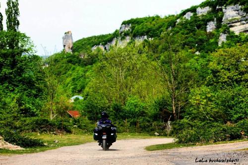a person riding a motorcycle down a dirt road at Butichi Guest House in Chiatʼura