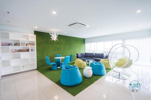a living room with blue furniture and a green wall at Pangsapuri Meridian by RR JBcity in Nusajaya