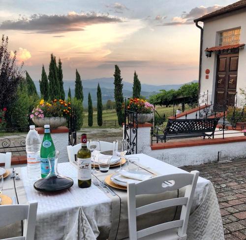 a white table with chairs and bottles of wine at Podere Belvedere in Barberino di Mugello