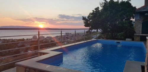 a swimming pool on top of a house with the sunset at Villa Sukara in Makarska