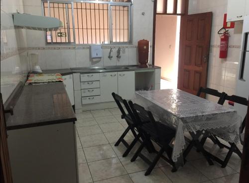 uma cozinha com uma mesa e uma mesa e cadeiras em Hospedaria Central Diamantina em Diamantina