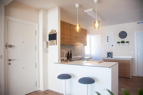 uma cozinha com um balcão e dois bancos em Apartamento con Vistas al MAR em Alicante