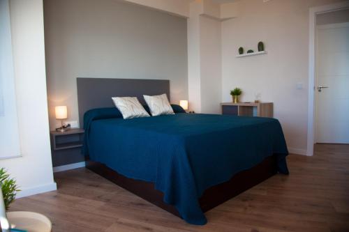 una camera con letto blu e 2 cuscini di Apartamento con Vistas al MAR ad Alicante