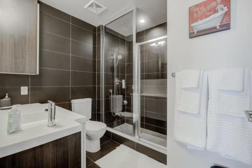 a bathroom with a toilet sink and a shower at CHOL Furnished Suites Heart of Downtown Toronto, 2 Beds, Free Parking, CN Tower View in Toronto