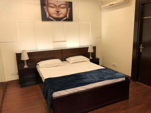 1 dormitorio con 1 cama grande con cabecero en Beautiful Apartments at Tarudhan Valley Golf Resort, Manesar en Gurgaon