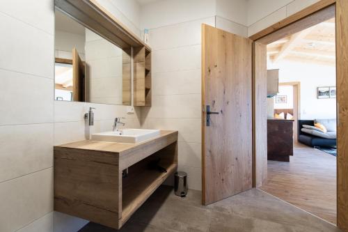 a bathroom with a sink and a wooden door at Binter Apartments in Virgen