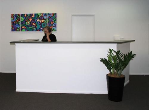 a woman standing in front of a white counter top at Aspley Motor Inn in Brisbane