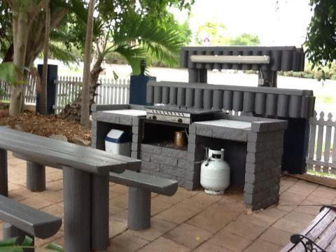 a black and white cat sitting on a wooden bench at Aspley Motor Inn in Brisbane