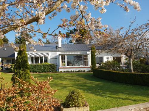 a white house with a green yard at Whiteacres in Invercargill